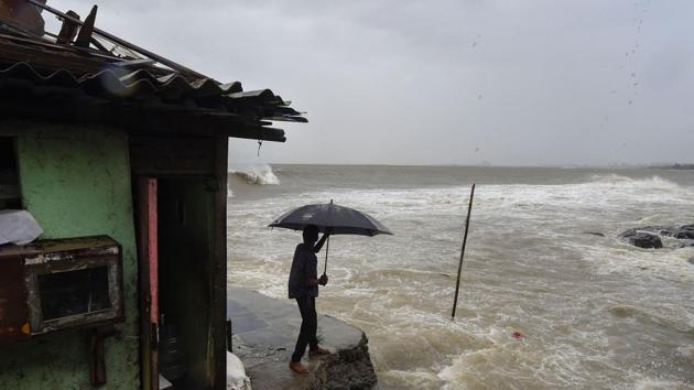 A man stands near a house built on the edge of the Arabian Sea at Bandra, ahead of Cyclone Nisarga’s expected landfall, in Mumbai, on Wednesday.(PTI Photo)