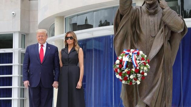 U.S. President Donald Trump and first lady Melania Trump pose beside a statue of Pope John Paul II as they visit the Saint John Paul II National Shrine in Washington, U.S., June 2, 2020. REUTERS/Tom Brenner(REUTERS)
