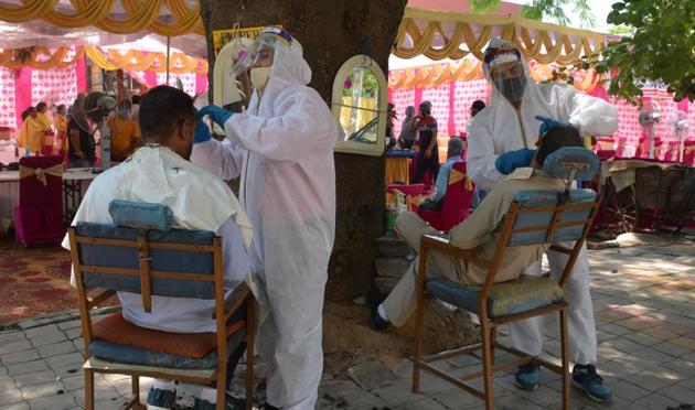 Barbers wearing protective clothing while serving customers in Sector 9, Panchkula. (Sant Arora/HT) Barbers wearing protective clothing while serving customers in Sector 9, Panchkula. (Sant Arora/HT)