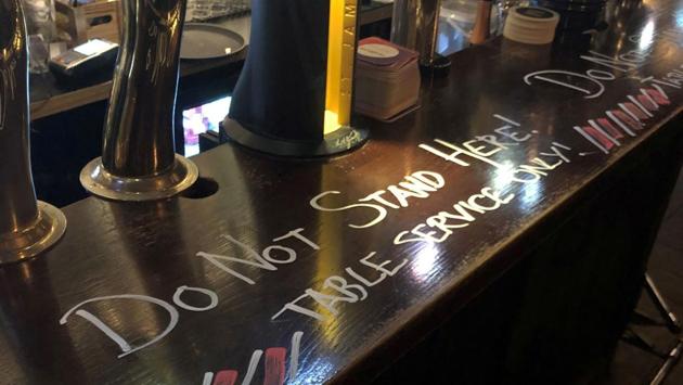 View of a warning message that customers cannot stand at the bar and must wait at tables to be served during the coronavirus outbreak, at a pub in Stockholm, Sweden. (REUTERS)