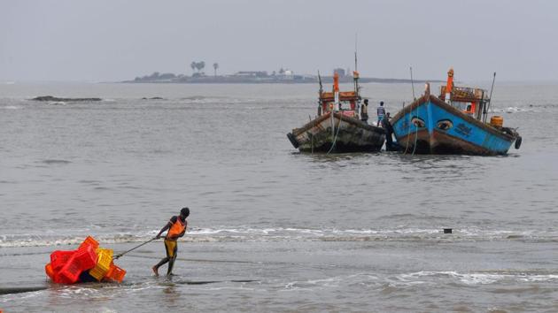 A fisherman pulls a handcart filled with crates towards inland at Madh fishing village, Mumbai. “Landfall is just beginning. It will take three hours to complete the process,” Jenamani told HT. (Indranil Mukherjee / AFP)
