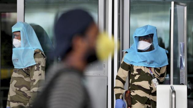 A passenger walks past Indian security personnel wearing protective gear at the departure terminal entrance of Kempegowda International Airport in Bengaluru, India. (AP) A passenger walks past Indian security personnel wearing protective gear at the departure terminal entrance of Kempegowda International Airport in Bengaluru, India. (AP)