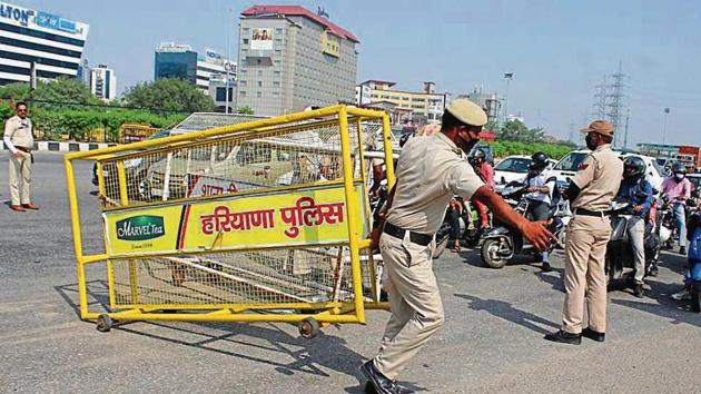 Gurugram police personnel remove barricades along the border with Delhi near Ambience Mall on Wednesday. (Yogendra Kumar/HT PHOTOs) Gurugram police personnel remove barricades along the border with Delhi near Ambience Mall on Wednesday. (Yogendra Kumar/HT PHOTOs)