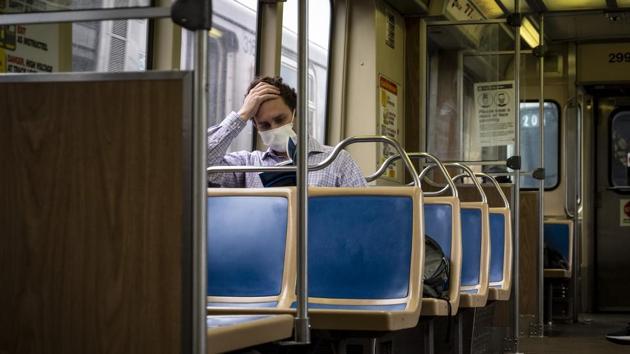 A commuter wearing a protective mask rides a Chicago Transit Authority (CTA) train in Chicago, Illinois, US on Wednesday. (Bloomberg Photo) A commuter wearing a protective mask rides a Chicago Transit Authority (CTA) train in Chicago, Illinois, US on Wednesday. (Bloomberg Photo)