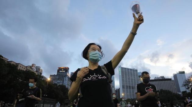 A woman holds up a candle at Victoria Park during the annual candle-light vigil. Hong Kong was engulfed by seven straight months of huge and often violent pro-democracy protests last year. (Paul Yeung / Bloomberg) A woman holds up a candle at Victoria Park during the annual candle-light vigil. Hong Kong was engulfed by seven straight months of huge and often violent pro-democracy protests last year. (Paul Yeung / Bloomberg)