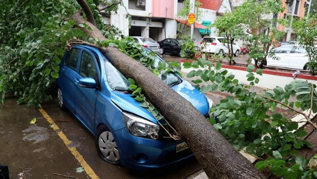 A car left damaged after an uprooted tree fell on it due to Cyclone Nisarga, in Thane on June 4. Once the storm had abated on Wednesday evening, personnel from the 20 NDRF teams deployed and district administration assessed the damage and began restoration work. (PTI) 