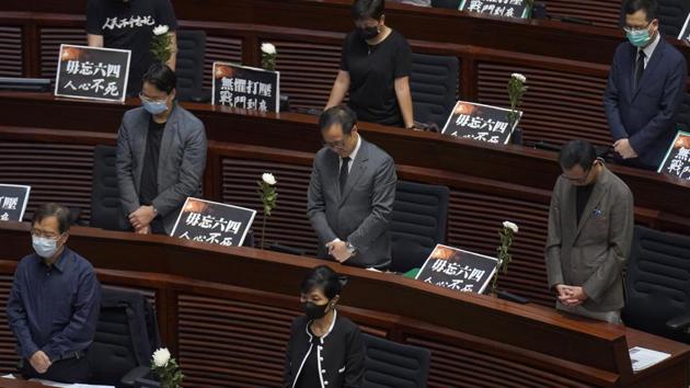 Pan-democratic legislators observe one minute of silence on the 31st anniversary of the Tiananmen crackdown before a Legislative Council meeting to debate the national anthem bill in Hong Kong on June 4. On the anniversary of Tiananmen crackdown, Hong Kong continued debating a contentious law that makes it illegal to insult or abuse the Chinese national anthem. (Vincent Yu / AP) Pan-democratic legislators observe one minute of silence on the 31st anniversary of the Tiananmen crackdown before a Legislative Council meeting to debate the national anthem bill in Hong Kong on June 4. On the anniversary of Tiananmen crackdown, Hong Kong continued debating a contentious law that makes it illegal to insult or abuse the Chinese national anthem. (Vincent Yu / AP)