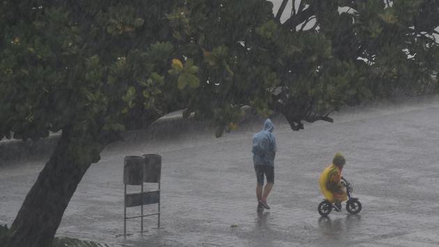 A child cycles in the rain along Marine Drive in Mumbai on June 4. Nisarga is now headed towards Madhya Pradesh, likely to cross over this evening from the southern parts of the state, instead of the western parts as predicted earlier by the IMD. (Punit Paranjpe / AFP) 
