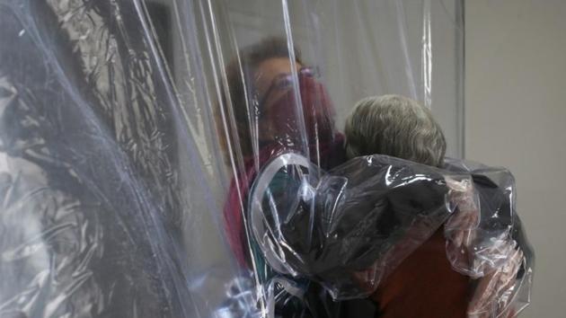 Dircyree Villas Boas hugs her mother Dirce Villas Boas, 93, through a plastic curtain at the 3i Bem-Estar - Residencial Senior nursing home.(Reuters)