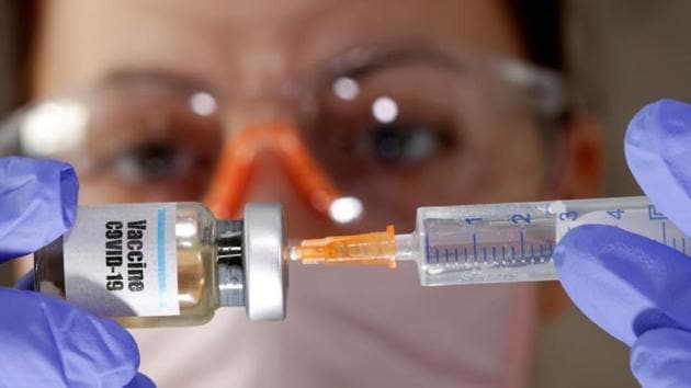A woman holds a small bottle labelled with a "Vaccine COVID-19" sticker and a medical syringe. (Reuters Photo) A woman holds a small bottle labelled with a "Vaccine COVID-19" sticker and a medical syringe. (Reuters Photo)