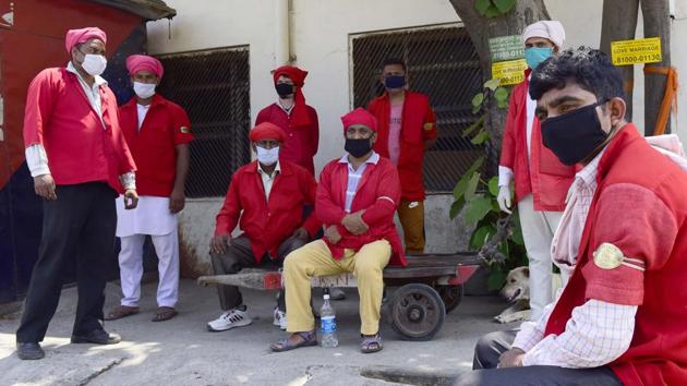 Coolies waiting for passengers at the Ludhiana railway station. The lockdown has left many of them without work.(Gurpreet Singh/HT)