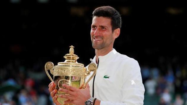 Serbia's Novak Djokovic poses with the trophy as he celebrates winning the final against Switzerland's Roger Federer.(REUTERS)