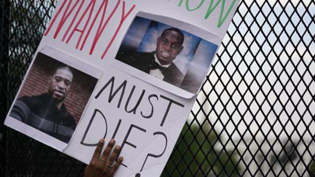 With the White House in the background, a sign is held up against a fence as demonstrators protest.(AP) With the White House in the background, a sign is held up against a fence as demonstrators protest.(AP)