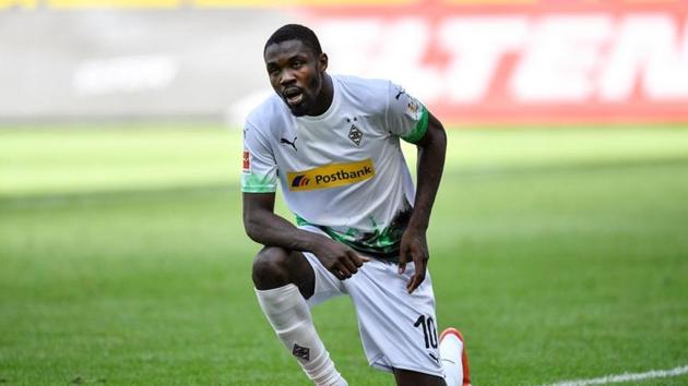 Borussia Moenchengladbach's Marcus Thuram kneels after celebrating their second goal. (REUTERS)