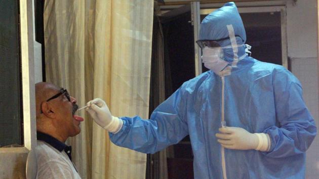 A health worker collects a swab sample of a man at a swab collection center during the nation-wide lockdown in the wake of Coronavirus. (ANI) A health worker collects a swab sample of a man at a swab collection center during the nation-wide lockdown in the wake of Coronavirus. (ANI)