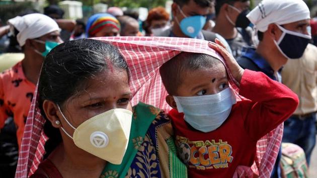 A migrant worker covers her child with a scarf to protect it from the heat, as they wait to get on a bus for a railway station, where they will board a train to their home state of West Bengal, after some restrictions were lifted during an extended nationwide lockdown to slow the spread of the coronavirus disease (COVID-19), in Ahmedabad, India, June 5, 2020.(REUTERS) A migrant worker covers her child with a scarf to protect it from the heat, as they wait to get on a bus for a railway station, where they will board a train to their home state of West Bengal, after some restrictions were lifted during an extended nationwide lockdown to slow the spread of the coronavirus disease (COVID-19), in Ahmedabad, India, June 5, 2020.(REUTERS)