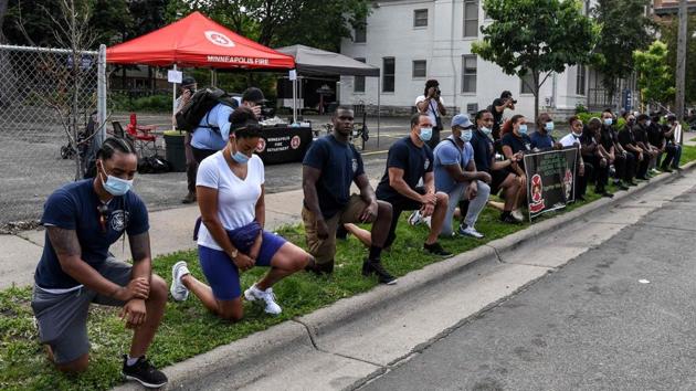 Minneapolis fire department officers kneel as the hearse with the casket containing the remains of George Floyd passes by during a memorial service in his honor on June 4 at North Central University's Frank J. Lindquist Sanctuary in Minneapolis, Minnesota. (Chandan Khanna / AFP) Minneapolis fire department officers kneel as the hearse with the casket containing the remains of George Floyd passes by during a memorial service in his honor on June 4 at North Central University's Frank J. Lindquist Sanctuary in Minneapolis, Minnesota. (Chandan Khanna / AFP)
