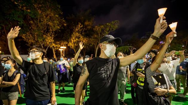 People wearing protective masks hold candles at Victoria Park to commemorate the 31st anniversary of the Tiananmen Square crackdown in Hong Kong, China. (Bloomberg) People wearing protective masks hold candles at Victoria Park to commemorate the 31st anniversary of the Tiananmen Square crackdown in Hong Kong, China. (Bloomberg)