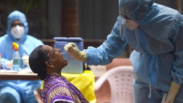 A doctor takes a swab sample of a resident at a Covid-19 coronavirus testing drive inside the Dharavi, Mumbai.(Satish Bate/HT Photo) A doctor takes a swab sample of a resident at a Covid-19 coronavirus testing drive inside the Dharavi, Mumbai.(Satish Bate/HT Photo)