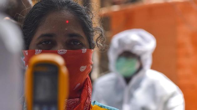 A doctor checks temperature of a resident at a Covid-19 coronavirus testing drive at Dharavi in Mumbai.(Satish Bate/HT Photo)