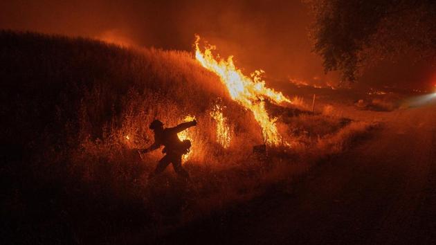 A firefighter tries to douse a backfire to stop advancing flames near Winters, California on June 6. A wildfire in northern California’s Solano County had charred at least 1,837 acres as of June 8 according to the California Department of Forestry and Fire Protection (CAL Fire). (Noah Berger / AP)