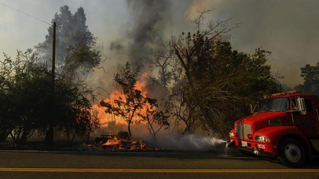 A truck sprays water while trying to contain the Quail Fire on June 6. State authorities had on June 6 issued mandatory residential evacuation orders for people living near the wildfire, the AP reported. The orders were lifted a day later with 100 structures considered at risk and 3 destroyed according to official figures. (Noah Berger / AP)