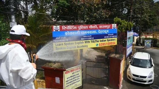 A firefighter sprays disinfectant at a police station in Dehradun as part of sanitisation drive.(PTI)