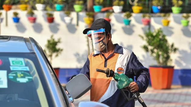 A petrol pump employee wearing a face shield while attending to a customer in Wazirpur, New Delhi.(Sanchit Khanna/HT Photo)