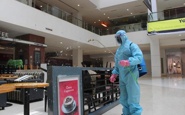 A worker sanitising the premises of VR Punjab Mall in Mohali on Sunday.(Gurminder Singh/HT)