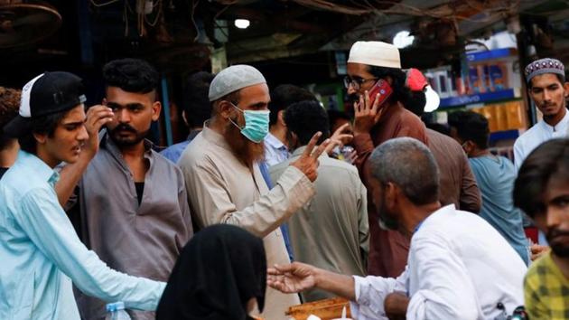 A man wearing a protective face mask gestures while shopping amid the rush of people outside an electronics market, after Pakistan started easing the lockdown restrictions, in Karachi, on June 4. (Reuters File Photo) A man wearing a protective face mask gestures while shopping amid the rush of people outside an electronics market, after Pakistan started easing the lockdown restrictions, in Karachi, on June 4. (Reuters File Photo)
