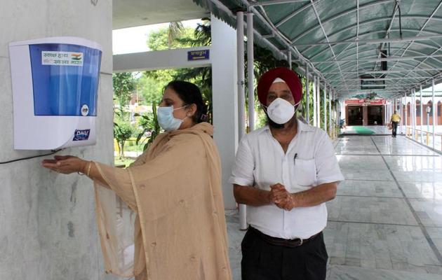 Devotees using an automatic hand sanitiser machine at the Phase 4 gurdwara in Mohali on Sunday.(Gurminder Singh/HT) Devotees using an automatic hand sanitiser machine at the Phase 4 gurdwara in Mohali on Sunday.(Gurminder Singh/HT)