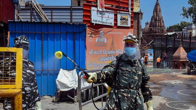A worker sanitises area around Kashi Vishwanath temple in Varanasi on Sunday. (PTI Photo) A worker sanitises area around Kashi Vishwanath temple in Varanasi on Sunday. (PTI Photo)