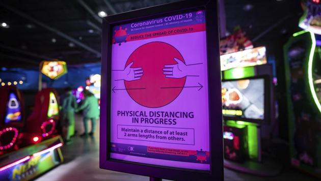 A sign reminds guests to practice physical distancing at Central City Fun Park on their opening weekend, in Surrey, British Columbia, Sunday, June 7, 2020. Due to the coronavirus pandemic, the indoor amusement park requires all guests to wear a face mask and has placed strict limits on the number of people permitted inside and time limits on how long they can stay per visit.(AP)