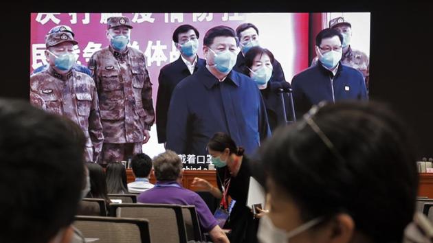 Journalists chat near a screen showing President Xi Jinping talks by video with patients and medical workers at the Huoshenshan Hospital in Wuhan in central China's Hubei Province. (AP) Journalists chat near a screen showing President Xi Jinping talks by video with patients and medical workers at the Huoshenshan Hospital in Wuhan in central China's Hubei Province. (AP)