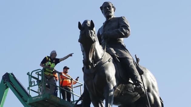 A crew inspect the statue of Confederate Gen. Robert E. Lee on Monument Avenue on June 8. In the United States, Virginia Governor Ralph Northam announced plans last week to remove this statue. At the time of the American Civil War, Virginia had been a slave-owning state, and Richmond had been the capital of the rebel Confederate states. (Steve Helber / AP)