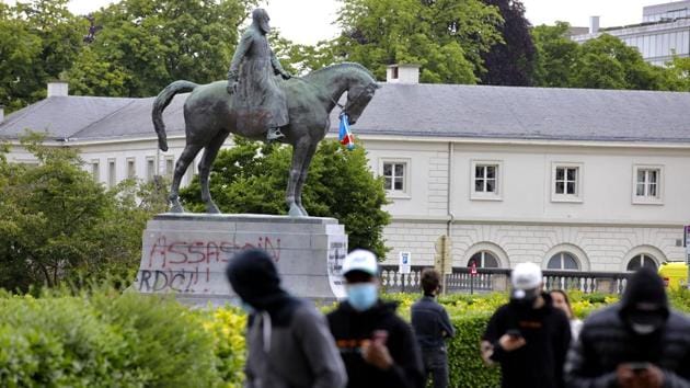 A statue of Belgium’s King Leopold II is defaced with the words ‘assassin’ prior to a Black Lives Matter protest rally in Brussels on June 7. In Belgium, an online petition calling for the removal of statues of colonial-era King Leopold II has garnered more than 30,000 signatures. His troops decimated Congo in the late 1800s. (Olivier Matthys / AP)