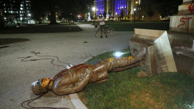 The statue of Confederate Gen. Williams Carter Wickham lies on the ground after protesters pulled it down on June 6 in Richmond’ s Monroe Park where it had stood since 1891. The debate over building and monuments named after people involved in the trans-Atlantic slave trade has been brewing for some years fuelled by the world’s recently adopted drive to end modern slavery. (Alexa Welch Edlund / Richmond Times-Dispatch via AP)