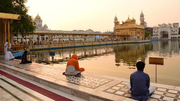 Devotees offer prayers outside the Golden Temple shrine after it reopened for public since the nationwide lockdown was imposed to curb the spread of coronavirus in Amritsar, Punjab on Monday.(Sameer Sehgal/HT Photo)