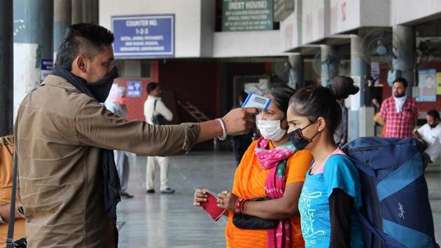 A conductor screening the passengers before they board a bus at the ISBT, Sector 43, Chandigarh.(Gurminder Singh/HT)