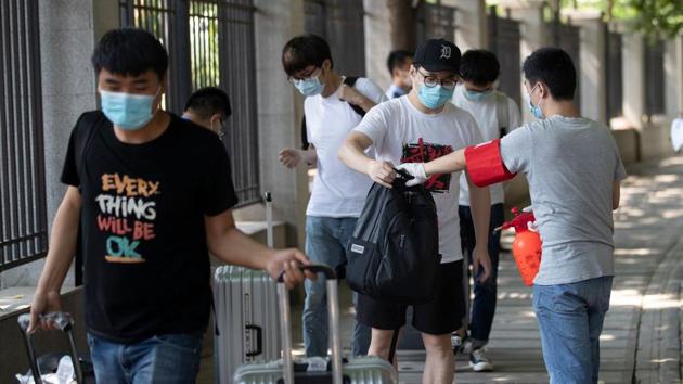 A student enters a dorm room at Wuhan University, China, on the first day of classes on June 8, 2020. The first cases of Covid-19 disease emerged in Wuhan late last year.(AFP)
