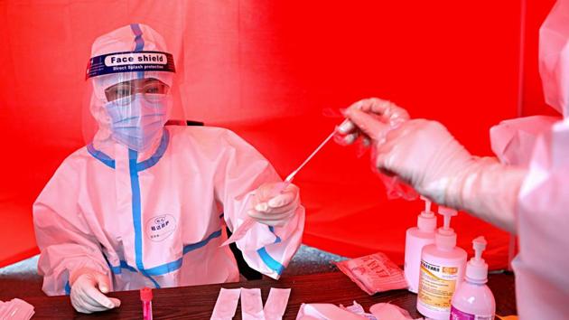 A medical worker collects a sample of a person to be tested for the Covid-19 coronavirus on a street in Mudanjiang, China’s northeastern Heilongjiang province. (AFP) A medical worker collects a sample of a person to be tested for the Covid-19 coronavirus on a street in Mudanjiang, China’s northeastern Heilongjiang province. (AFP)