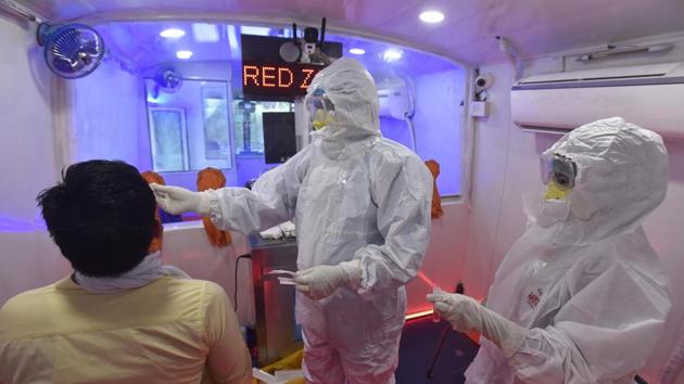 A medical worker takes a swab sample for Covid-19 testing in a bus converted into a mobile coronavirus testing clinic in New Delhi,on Monday.(Sonu Mehta/HT PHOTO)
