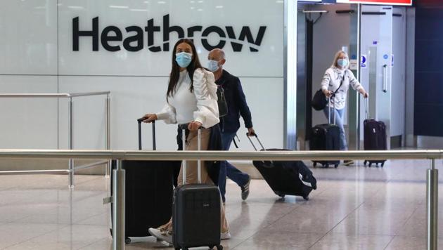 Passengers, wearing protective face masks, walk through the international arrivals hall after arriving at Terminal 2 at London Heathrow Airport in London, UK on Monday. (Bloomberg) Passengers, wearing protective face masks, walk through the international arrivals hall after arriving at Terminal 2 at London Heathrow Airport in London, UK on Monday. (Bloomberg)