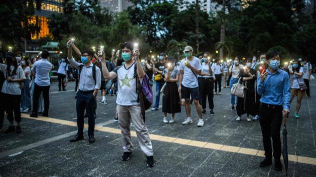 Pro-democracy protesters hold up their phones in the Central district of Hong Kong on June 9. Beyond a withdrawal of the extradition bill, the protest movement’s core demands, such as universal suffrage and an inquiry into police tactics, have been rejected by the city’s leadership and Beijing. Instead, China has unveiled plans to impose a more sweeping law -- one that will bypass the city’s legislature entirely. (Anthony Wallace / AFP)