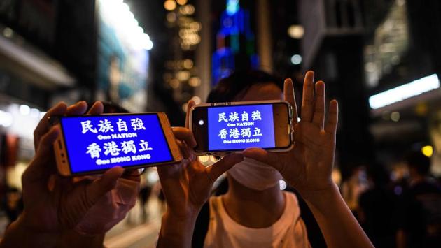 Protesters hold up their phone displays that read “One Nation One Hong Kong” during a rally to mark the first anniversary of pro-democracy protests in Hong Kong on June 9. (Anthony Wallace / AFP)