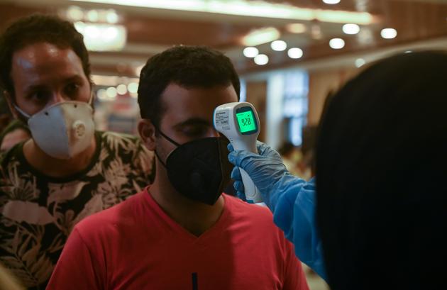 A doctor checks the body temperature of migrant workers and business owners upon returning from Goa after the government eased a nationwide lockdown as a preventive measures against the spread of the Covid-19 coronavirus.(AFP)