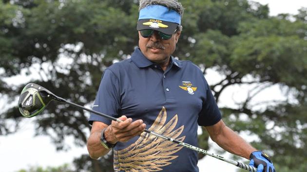Former cricketer and golfer Kapil Dev looks on before playing a shot.(AFP)