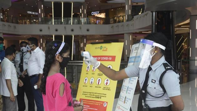 A security guard thermal screening people at South City Mall in Kolkata after it opened to the public on Monday, June 8, 2020.(Samir Jana / HT Photo)