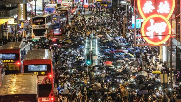Demonstrators march on Des Voeux Road Central to mark a year since pro-democracy protests erupted in Hong Kong. Months of massive and often violent rallies kicked off on June 9 last year when as many as one million people took to the streets to oppose a bill allowing extraditions to mainland China. (Roy Liu / Bloomberg)