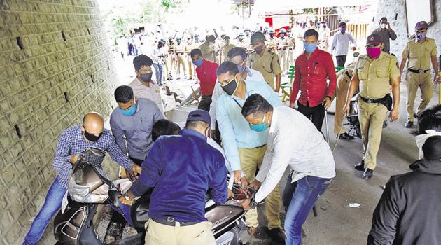 The two-wheelers parked by the police officials at Anandnagar were pushed into gutters and chairs were thrown by residents on Monday, according to the police.(HT PHOTO) The two-wheelers parked by the police officials at Anandnagar were pushed into gutters and chairs were thrown by residents on Monday, according to the police.(HT PHOTO)